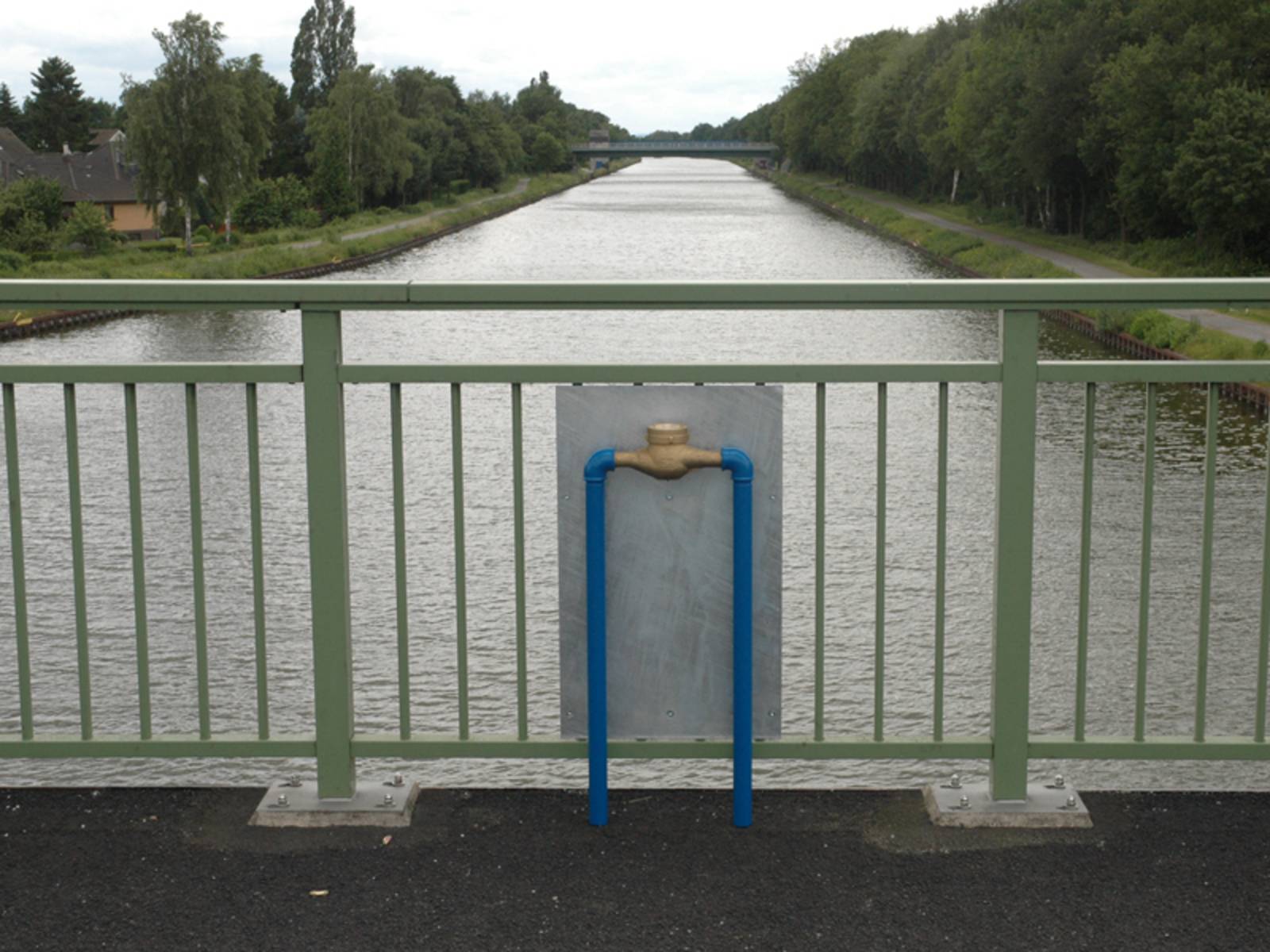 Ein Wasserzähler, der mit blauen Stahlrohren auf einer Brücke montiert ist